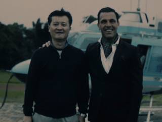 dva usmívající se muži stojí před helikoptérou