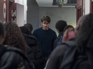 učitel stojí uprostřed mezi dětmi, které jsou otočeny zády