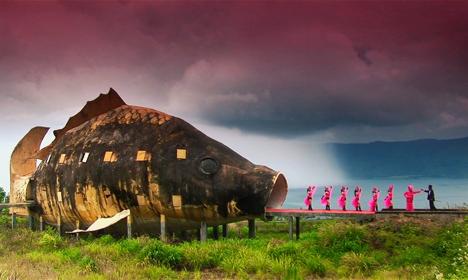 postavy v růžovém vycházejí z budovy ve tvaru velké ryby